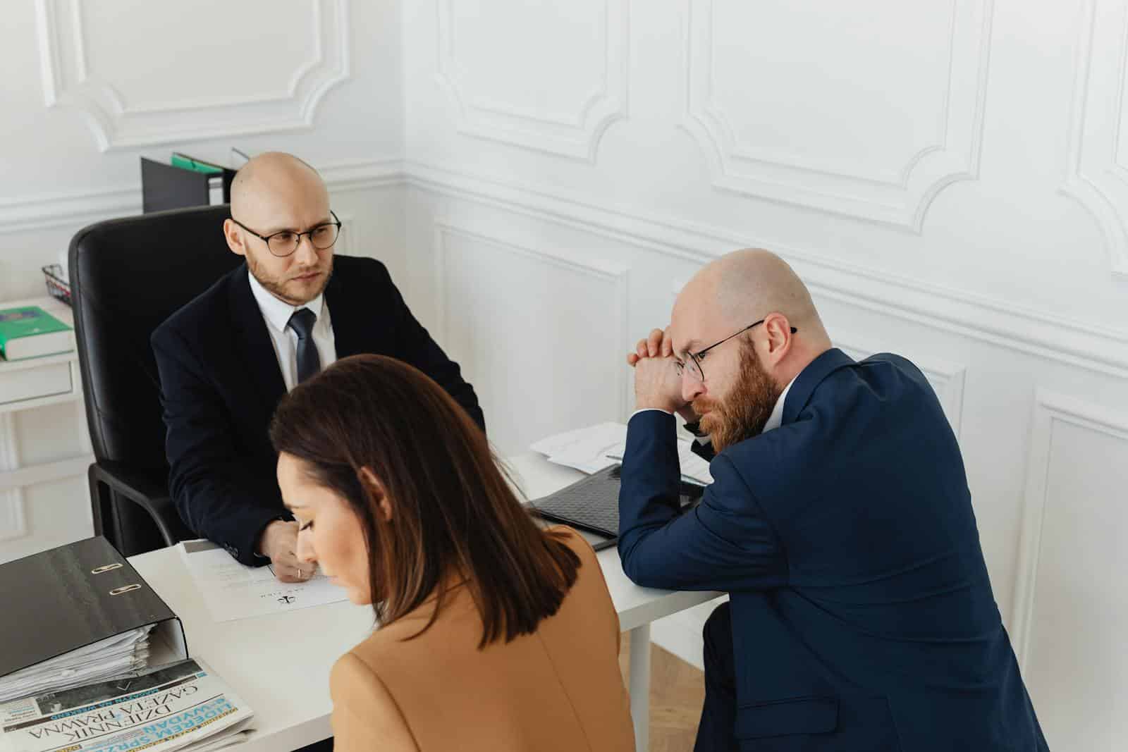 Three business professionals engaged in a meeting in a stylish office setting.